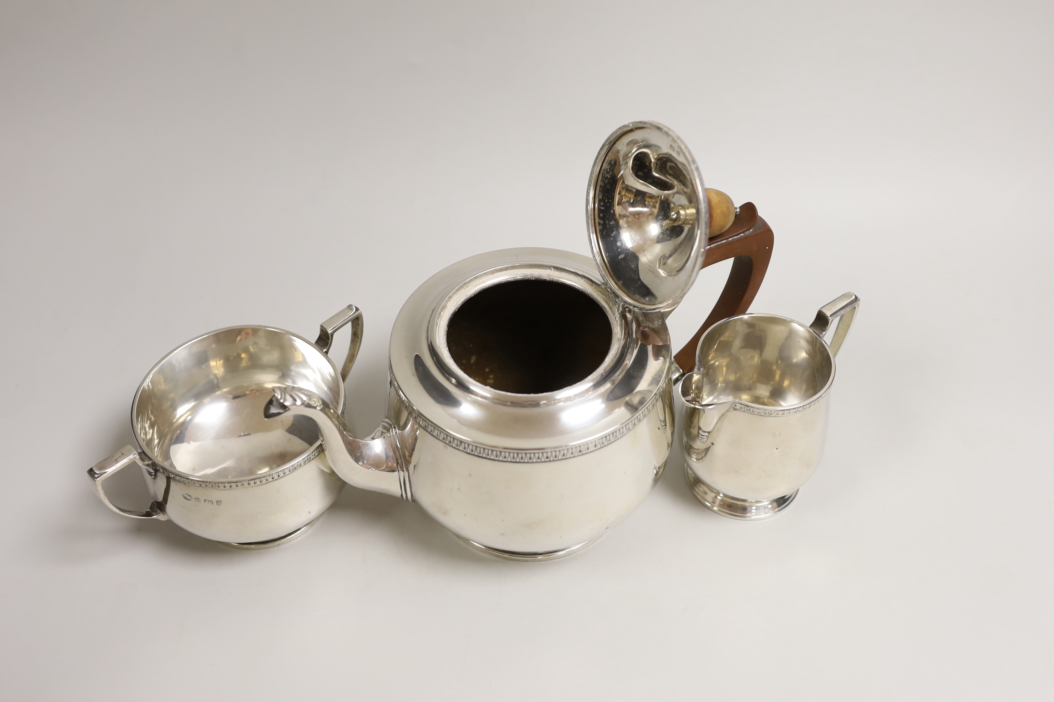 A George V silver circular three piece tea set, Alexander Clark Co, Birmingham, 1930, gross weight 26.3oz.